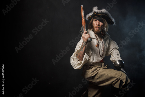 Portrait of pirate filibuster sea robber in suit with guns. Concept photo