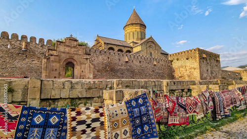 Carpets hanging on the wall of the cathedral of saint kura and the mtskheta river in the town of svetitskhoveli, a historic monument for tourism and religion in the caucasus region. Cathedral. photo