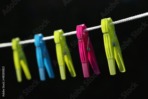 A close-up of colorful clothes pegs on a washing line 