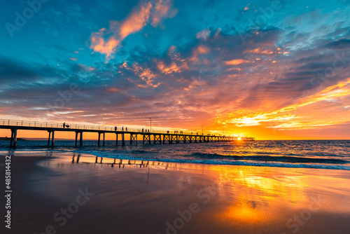 Foto Dramatic sunset viewed towards Port Noarlunga jetty with people strolling along,