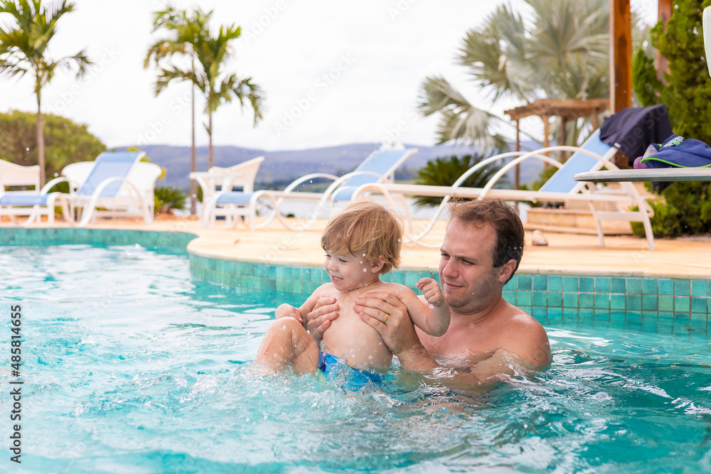 father playing with his son in the pool, narrow focus