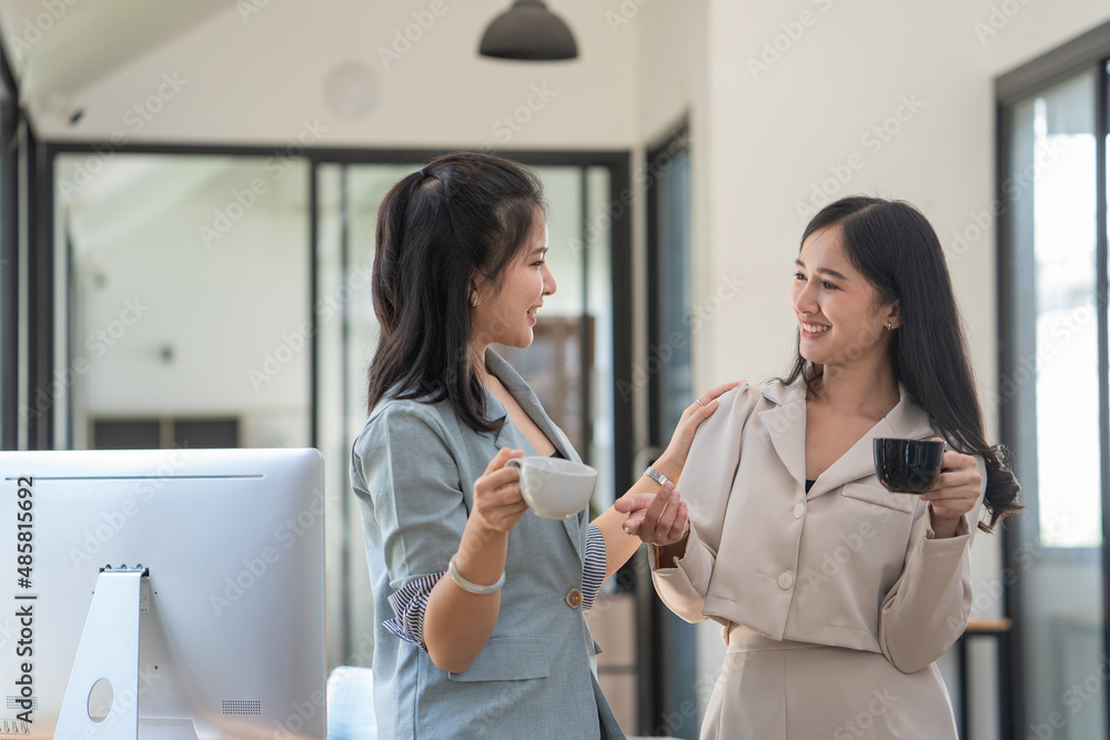 businesswoman standing and talking with a friend and drinking coffee while time break businesswoman standing and talking with a friend and drinking coffee while time break