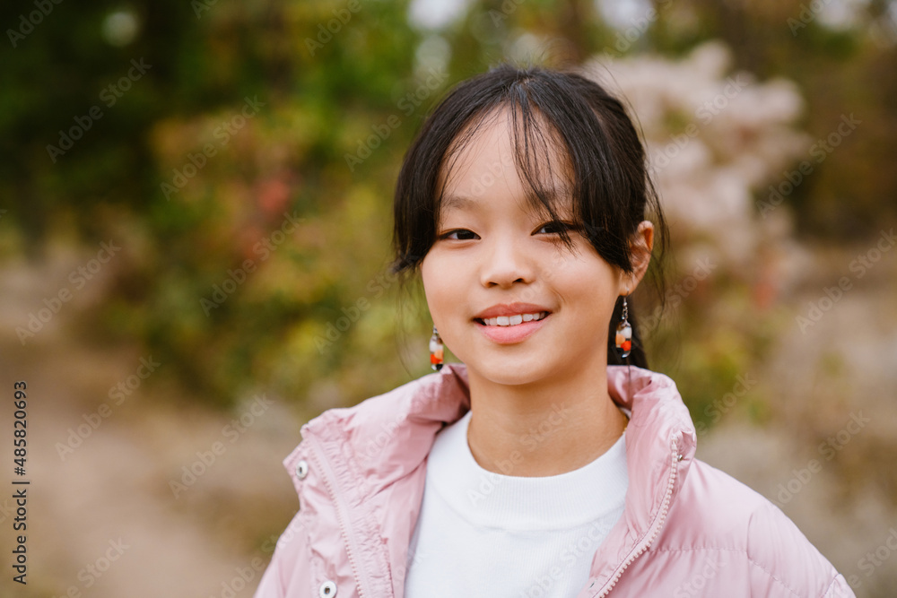 Asian girl wearing jacket smiling and looking at camera Asian girl wearing jacket smiling and looking at camera