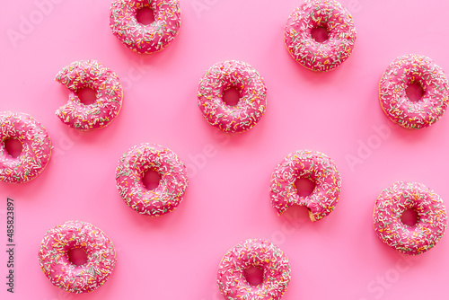 Pink frosted donuts with colorful sprinkles. Bakery background