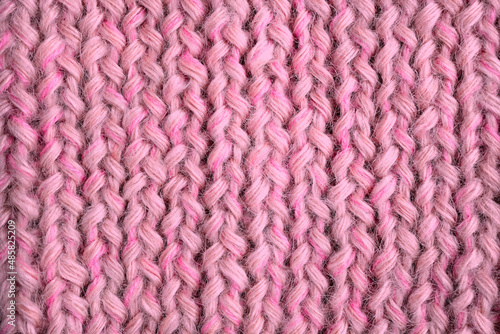  Knitwear in calm pink is on the table - this is the fashionable color trend of 2022. View from above. Flat lay, top view, close-up, macro, can be used for background.