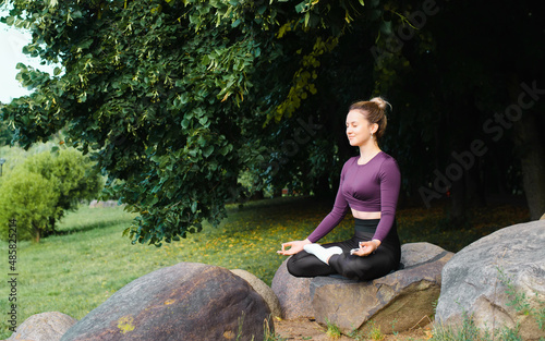 Wallpaper Mural Meditation, yoga and mindfulness practice outdoors. Caucasian young woman with closed eyes sitting in lotus position on stone, practicing yoga asana in park, relaxing, recreation. Copy space Torontodigital.ca