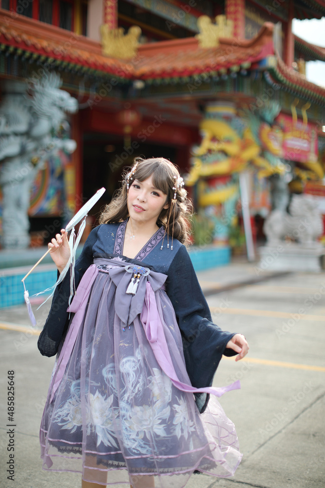 Obraz premium Beautiful young woman with dark blue Chinese lolita dress with Chinese garden