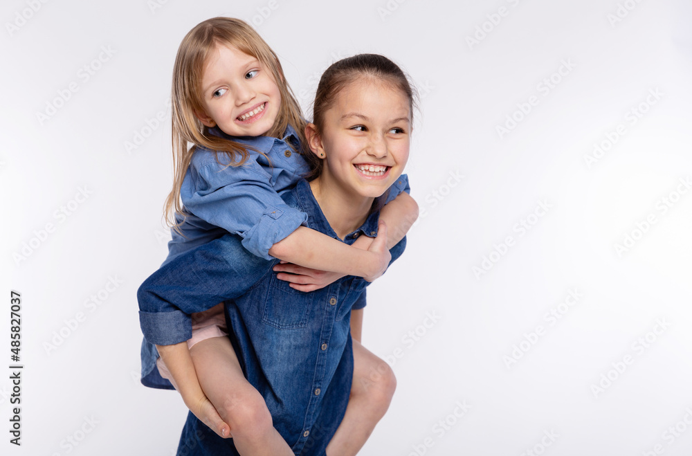 Two happy friends or sisters kid girls hugging. Together having fun and posing emotional on white background, happy smiling, friendship and relationship lifestyle people concept Two happy friends or sisters kid girls hugging. Together having fun and posing emotional on white background, happy smiling, friendship and relationship lifestyle people concept