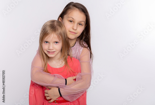Two happy best friends or sisters kid girls hugging. Together having fun and posing emotional on white background, happy smiling, friendship and relationship lifestyle people concept