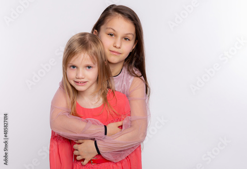 Two happy best friends or sisters kid girls hugging. Together having fun and posing emotional on white background, happy smiling, friendship and relationship lifestyle people concept