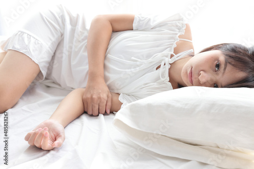 Beautiful young woman legs sleeping in the morning at white bedroom