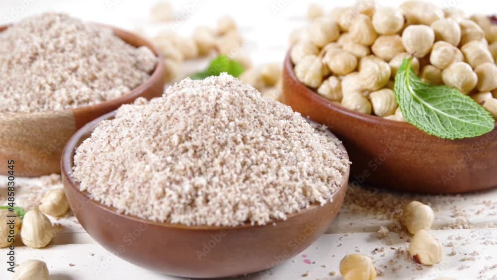 Alternative keto diet gluten grain free flour. Paleo and ketogenic diet baking cooking concept. Hazelnut flour with whole nuts Alternative keto diet gluten grain free flour. Paleo and ketogenic diet baking cooking concept. Hazelnut flour with whole nuts