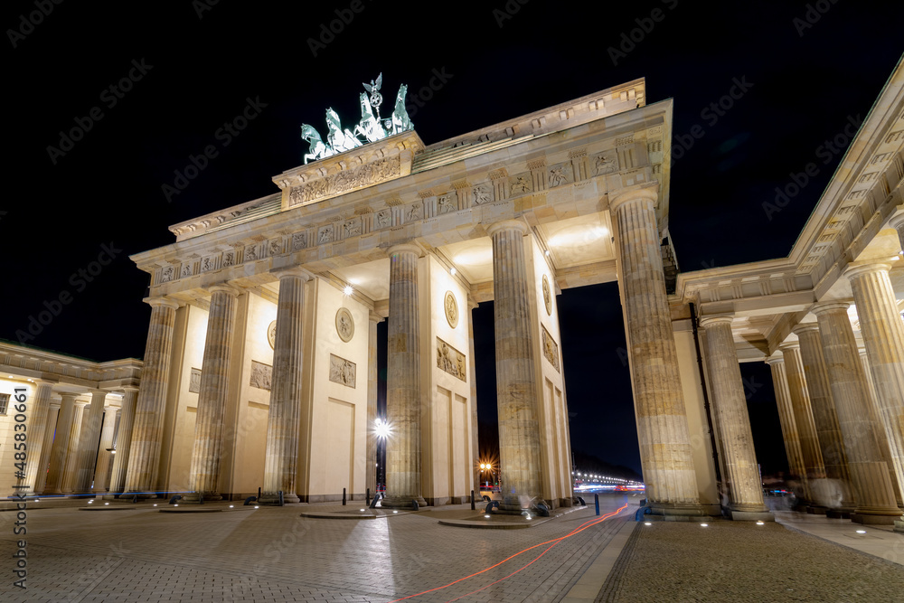 Obraz premium Night cityscape of the famous city gate Brandenburger Tor in the evening, Neoclassical monument, One of the best-known landmarks of Germany, Located in the western part of the city centre of Berlin.