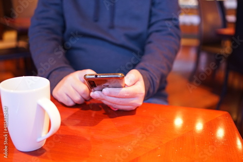 Man using smartphone at cafe  texting on his mobile phone  -                                         