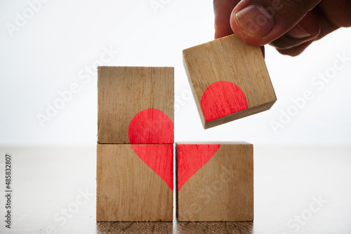 Love symbol or sign on a wooden block over white background