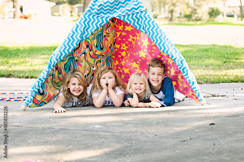 four kids in tent outside