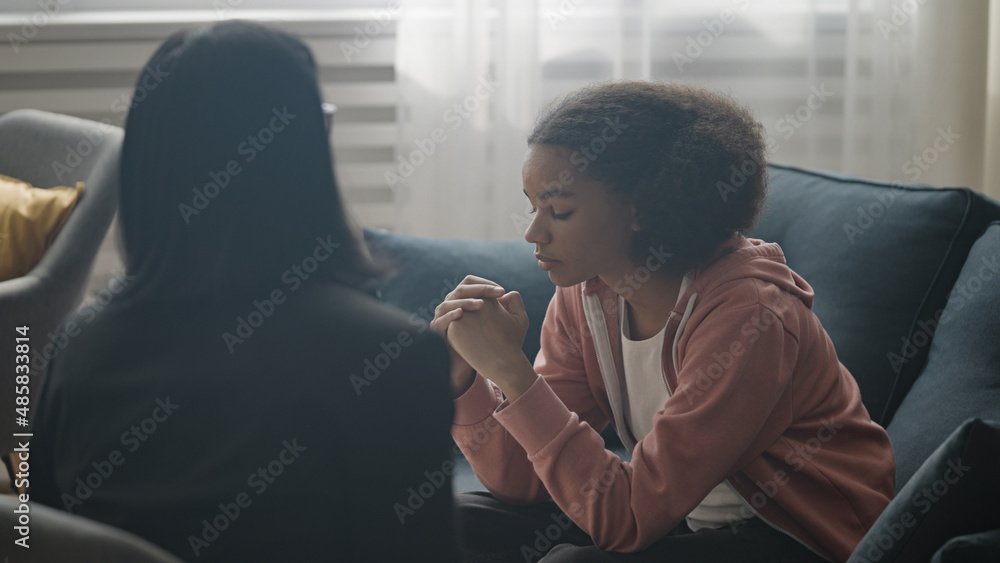Fototapeta premium Female therapist talking to upset teen girl at counselling session, psychology