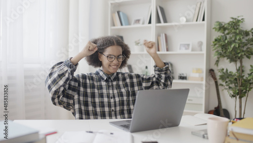 Фотография Female student successfully finishing school project, raising hands in joy, onli