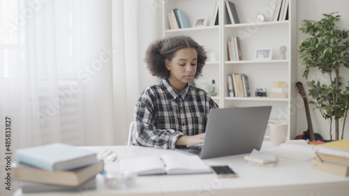 Foto Teenage girl typing on laptop, creating online blog, adding content, part-time j