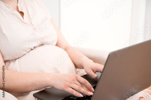 Pregannt woman usong laptop for remote work from home