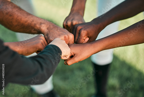 We play to win. Cropped shot of a group of unrecognizable baseball players putting their hands together.