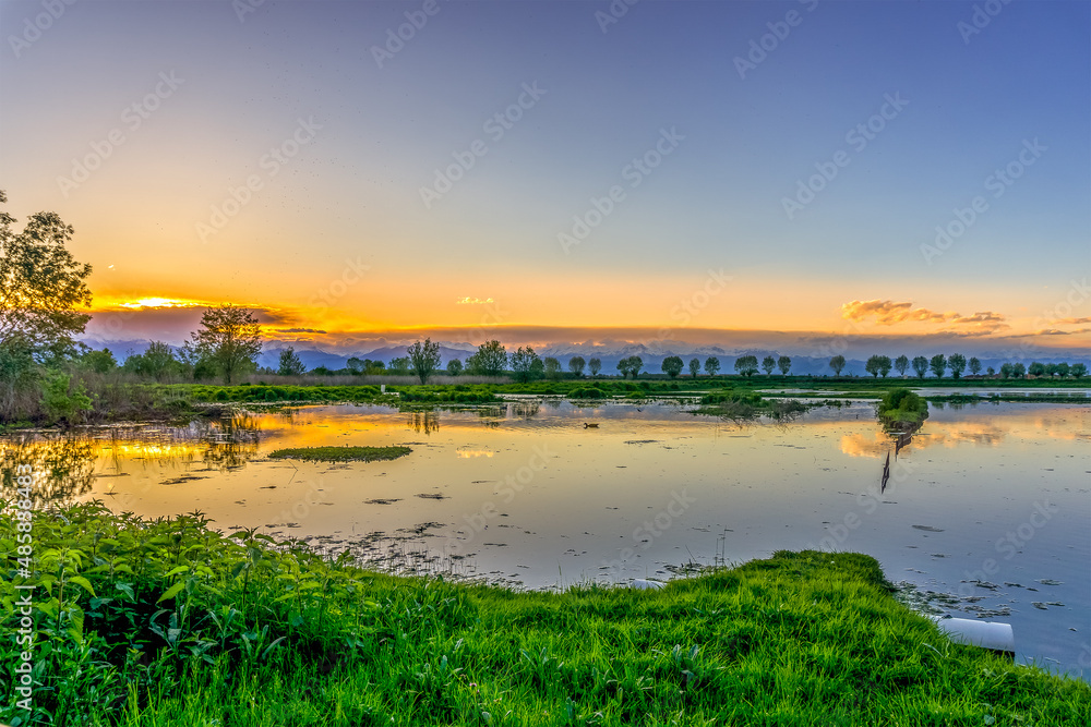 Beautiful, colorful sky over a lake at sunset with reflection, in italy near Turin. Peaceful scene, no one people