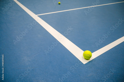 Tennis ball on white line on blue hard tennis court. © Anastasia