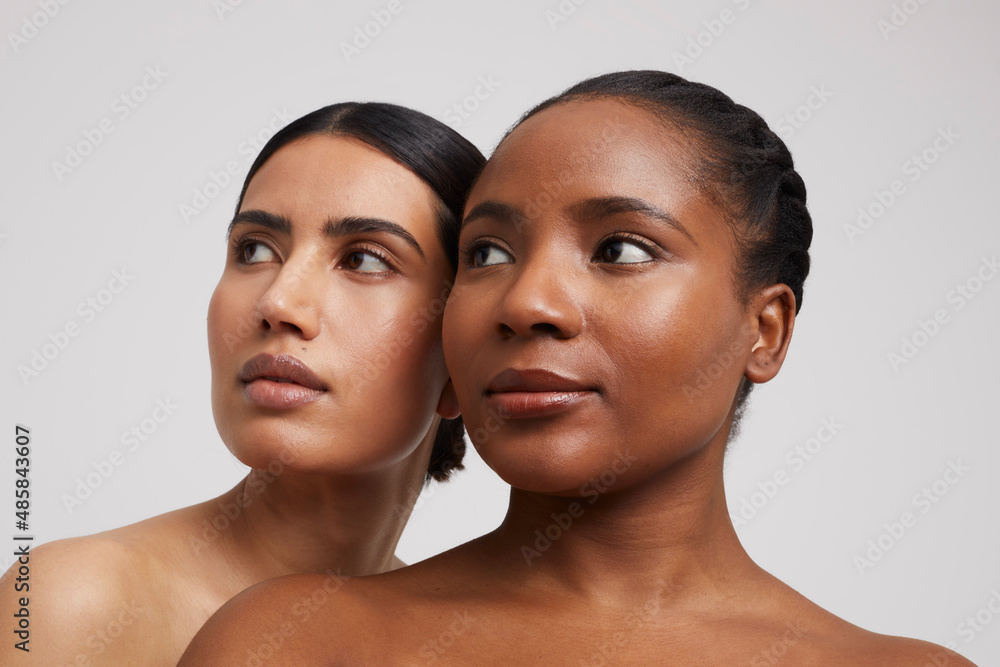Studio shot of two pensive women looking up Studio shot of two pensive women looking up