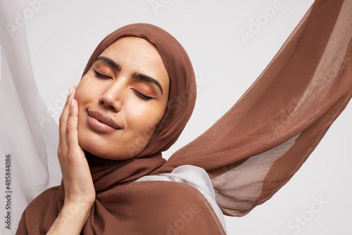 Tablou pe pânză Studio portrait of smiling woman wearing brown hijab