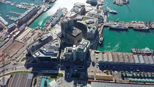 Semi top down aerial shot circling around the central part of the harbor district in Cape Town with luscious blue water surrounding it on all sides.