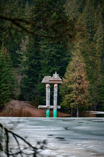 Alpine lake Synevyr, wooden statues near the lake, a tourist place in Ukraine, ice on the lake. photo