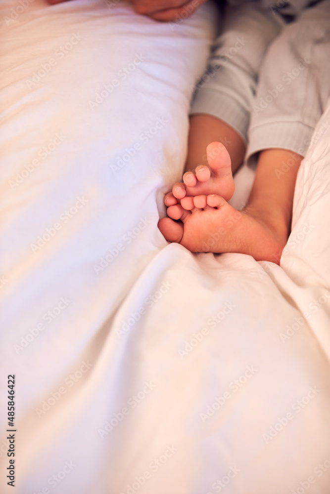 Close Up Of Young Girl's Feet Wearing Pyjamas Lying On Bed At Home Close Up Of Young Girl's Feet Wearing Pyjamas Lying On Bed At Home