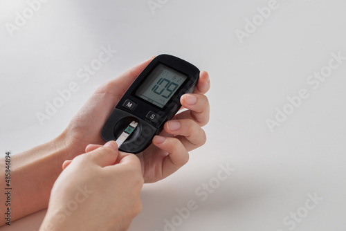 Diabetes concept, Human checking blood sugar level with glucometer.