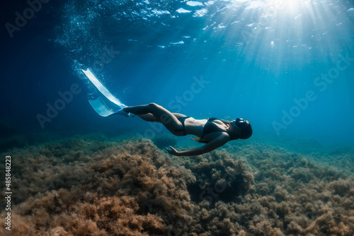 Free diver with white fins posing underwater. Freediving with young girl