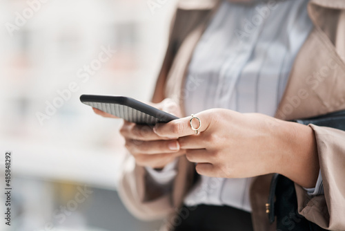 Getting around is easier when you have the world at your fingertips. Cropped shot of an unrecognizable woman using her cellphone against a city background.