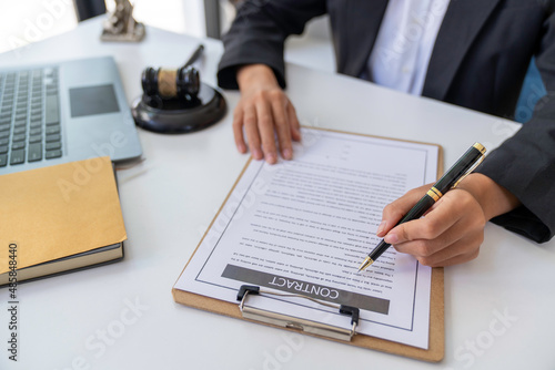 A judge takes a hammer with a lawyer for justice. A businesswoman in a suit or a lawyer works on documents, laws, advice and justice concepts. Signing documents for justice and decide the lawsuit