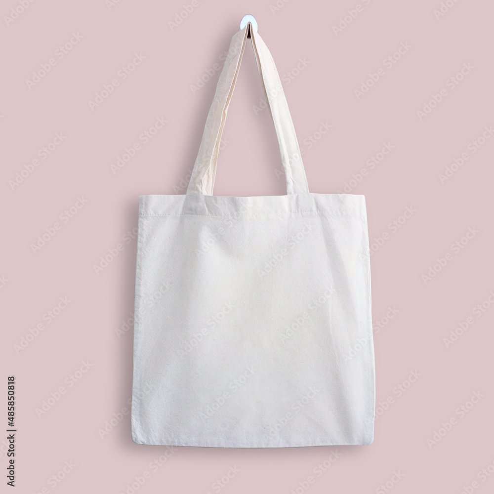 White blank cotton eco tote bag, design mockup. Shopping bag hanging on  wall Stock Photo