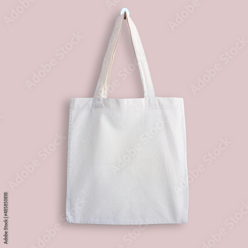 White blank cotton eco tote bag, design mockup. Shopping bag hanging on wall