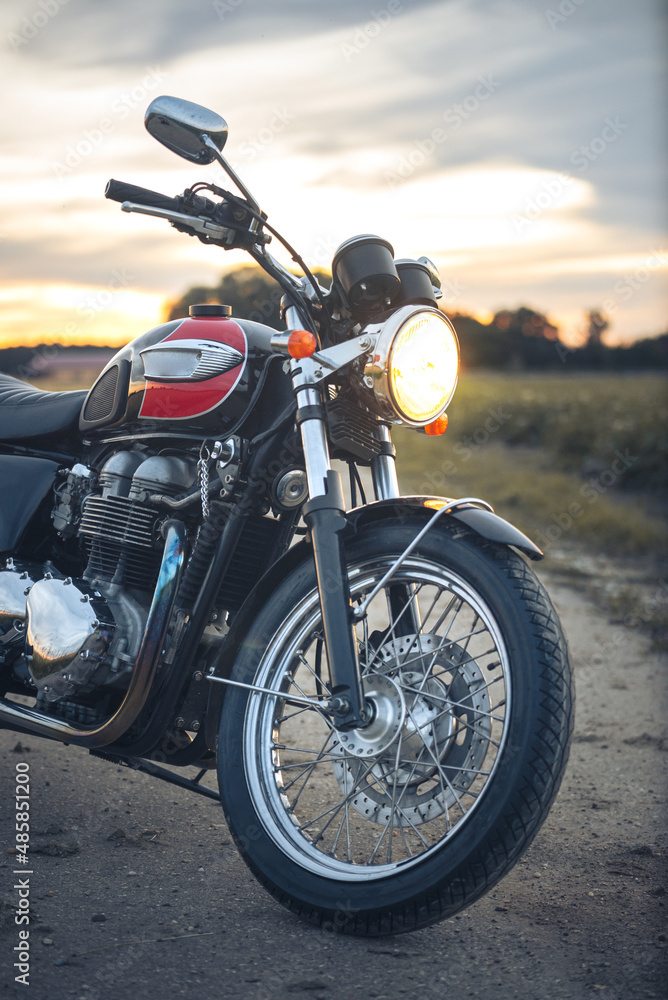 Caffeeracer Motorrad auf Feldweg im Sonnenuntergang Caffeeracer Motorrad auf Feldweg im Sonnenuntergang