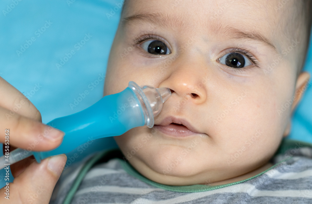 father using nasal aspirator for cleaning little nose of his son, from mucus. Concept of kids, hygiene and healthcare. Caring parents with little children. toddler , cute baby boy faced to camera father using nasal aspirator for cleaning little nose of his son, from mucus. Concept of kids, hygiene and healthcare. Caring parents with little children. toddler , cute baby boy faced to camera