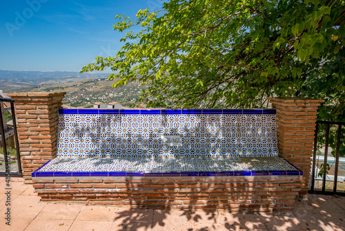 Mosaic bench with a nice view. Travel photograph, wonderful sunny spring day, Alcaucin, Malaga, Andalusia, Spain photo