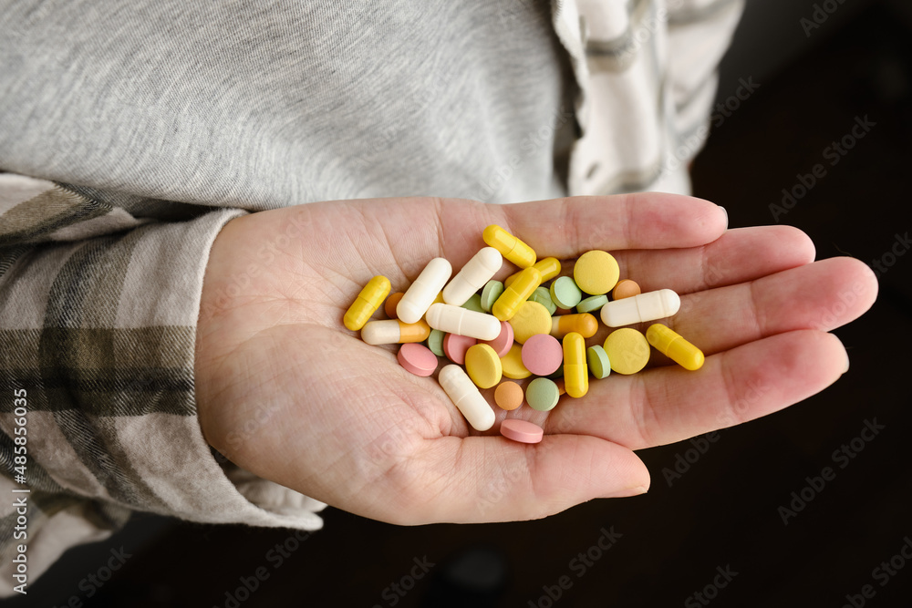 A hand holds an assortment of pills and vitamins close-up. Effective drugs, modern pharmacy for the body and mental health. The concept of healthcare, medicine, pharmacies, disease prevention A hand holds an assortment of pills and vitamins close-up. Effective drugs, modern pharmacy for the body and mental health. The concept of healthcare, medicine, pharmacies, disease prevention