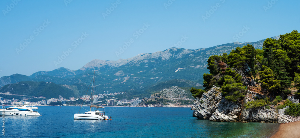 View on Budva from Sveti Stefan island in Montenegro. Adriatic sea with boats and mountains
