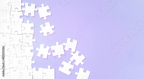 white puzzle pieces on pupple background with copyspace photo
