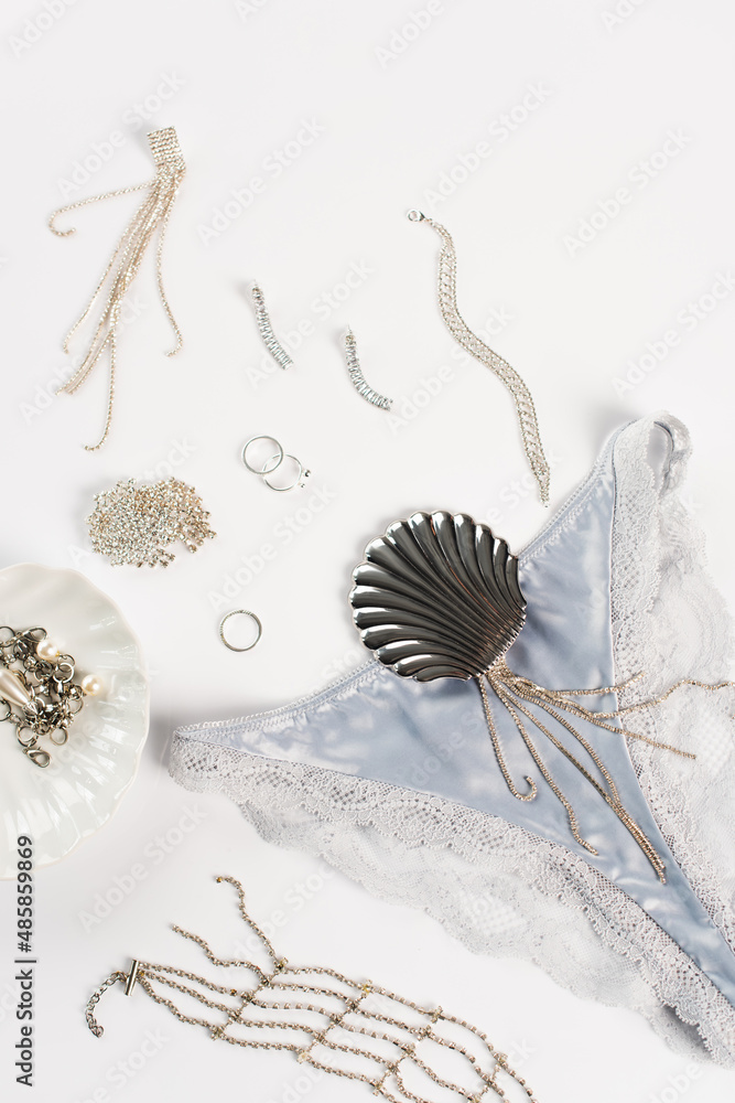 Top view of blue silk panties near accessories on white background Top view of blue silk panties near accessories on white background