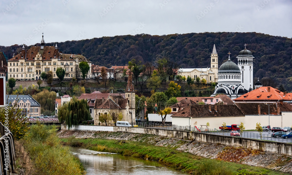 Ancient Sighisoara city in Romania, panoramic old clock tower, medieval architecture and scenic river view. Historic european town with Dracula house and beautiful nature