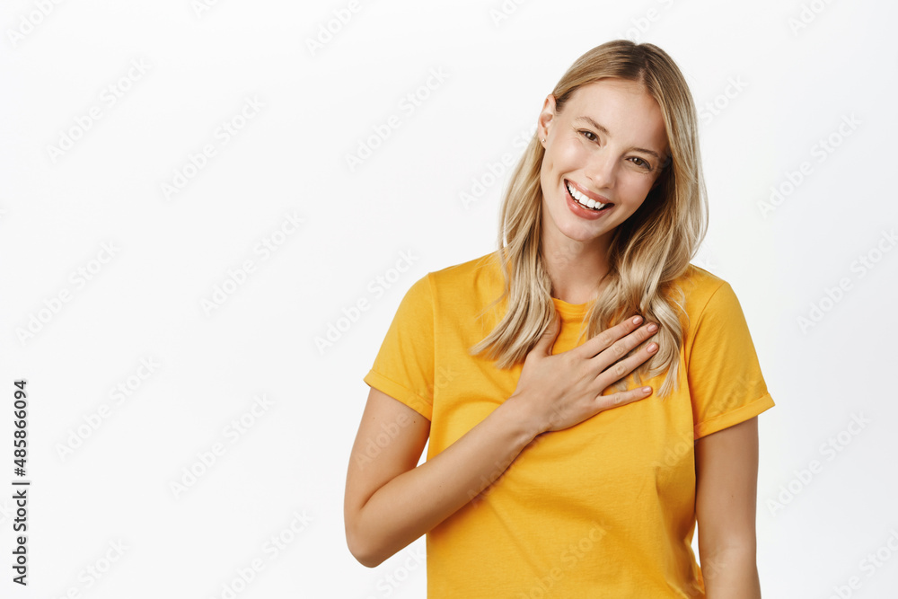 Smiling beautiful modern girl laughing, holding hand on heart appreciation gesture, grateful, say thank you, being pleased, receive compliment, white background Smiling beautiful modern girl laughing, holding hand on heart appreciation gesture, grateful, say thank you, being pleased, receive compliment, white background