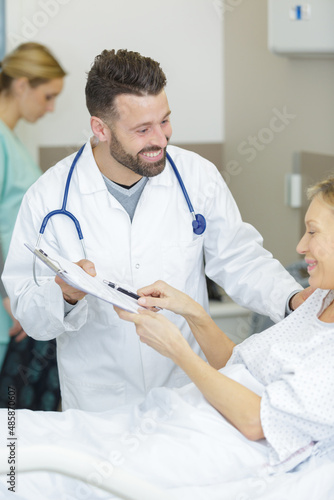 happy female patient signs the medical form