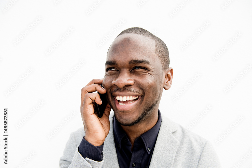 Close up smiling black businessman talking with cellphone by isolated white background Close up smiling black businessman talking with cellphone by isolated white background