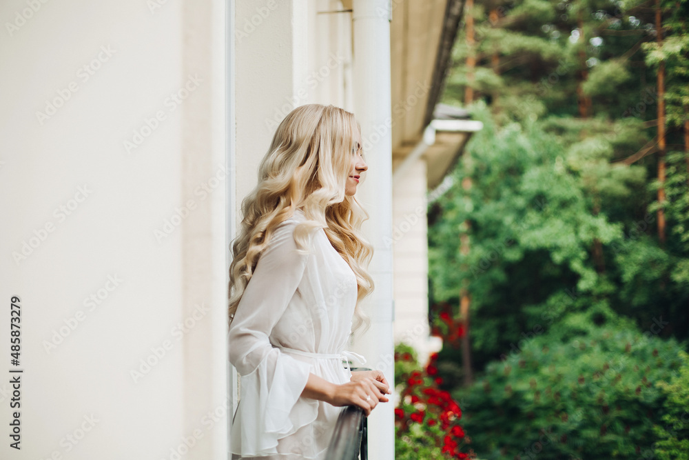 Gorgeous blondie bride walking at balcony and waiting for her groom. Gorgeous blondie bride walking at balcony and waiting for her groom.